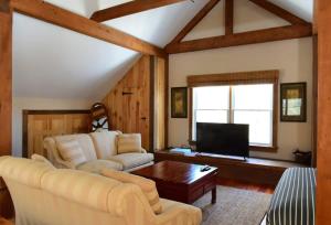 - un salon avec un canapé et une télévision dans l'établissement Berkshire Vacation Rentals: Peaceful Post and Beam Loft Sleeps 9, à New Marlborough