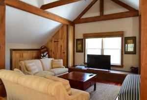 a living room with a couch and a tv at Berkshire Vacation Rentals: Peaceful Post and Beam Loft Sleeps 9 in New Marlborough