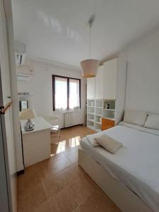 um quarto branco com uma cama grande e uma secretária em Nice Apartment in Margine Rosso em Quartu SantʼElena