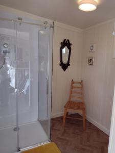a glass shower stall with a wooden stool in a room at The Cabins Conwy in Conwy