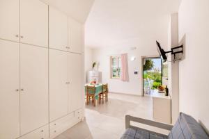 a living room with white cabinets and a table at Crovatico Club Vacanze in Vieste