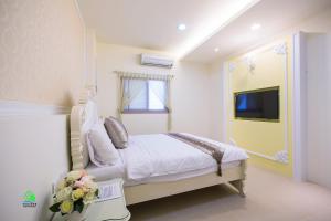 馬公市的住宿－澎湖森源民宿 SunYoung，一间卧室配有一张床,并在一间客房内配有电视。
