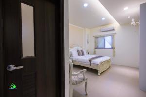 馬公市的住宿－澎湖森源民宿 SunYoung，一间卧室设有床、窗户和门
