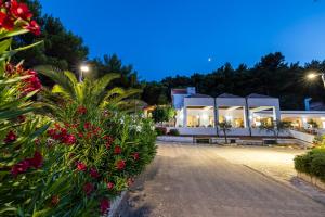 a view of a building at night with flowers at Crovatico Club Vacanze in Vieste