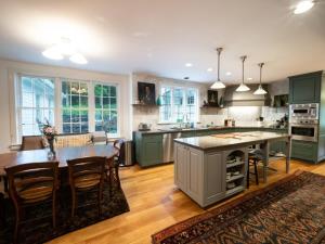 a kitchen with green cabinets and a table and chairs at Berkshire Vacation Rentals: Private Estate Heated YEARROUND Outdoor Pool in North Egremont
