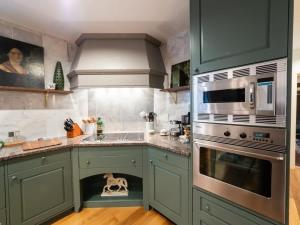 a kitchen with green cabinets with a dog in the drawer at Berkshire Vacation Rentals: Private Estate Heated YEARROUND Outdoor Pool in North Egremont +70 photos