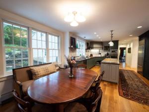una cucina con tavolo da pranzo e sedie in legno di Berkshire Vacation Rentals: Private Estate Heated YEARROUND Outdoor Pool a North Egremont