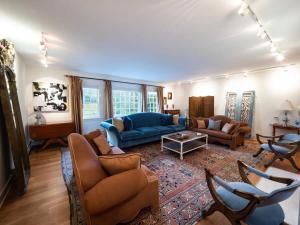 sala de estar con sofá azul y sillas en Berkshire Vacation Rentals: Private Estate Heated YEARROUND Outdoor Pool en North Egremont
