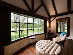 ein Wohnzimmer mit einem Sofa und einem großen Fenster in der Unterkunft Berkshire Vacation Rentals: Private Estate Heated YEARROUND Outdoor Pool in North Egremont
