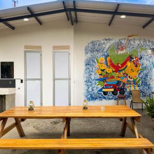 eine Holzbank vor einer Wand mit einem Gemälde in der Unterkunft La Familia Hostel - Manila in Medellín