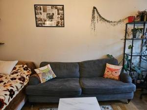 una sala de estar con un sofá azul con almohadas. en Lägenhet, 
