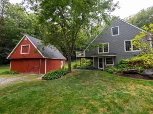 uma casa com um celeiro vermelho num quintal em Beautiful House In The Woods Huge Yard Hot Tub em Great Barrington