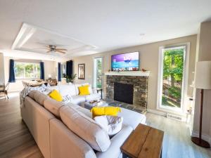 a living room with a couch and a fireplace at Berkshire Vacation Rentals: Leicester Lake Front Home Come Relax in Leicester