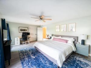 a bedroom with a large bed with a ceiling fan at Berkshire Vacation Rentals: Leicester Lake Front Home Come Relax in Leicester