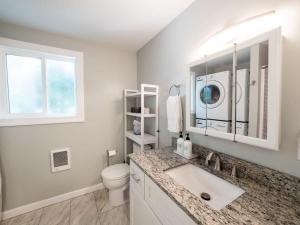 Baño blanco con lavabo y aseo en Berkshire Vacation Rentals: Leicester Lake Front Home Come Relax en Leicester