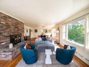uma sala de estar com lareira de tijolos e cadeiras azuis em Berkshire Vacation Rentals: Renovated Five Bedrooms In Historic Williamstown em Williamstown