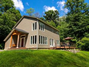 ein Haus mit einer Veranda und einer Terrasse auf einem Rasen in der Unterkunft Berkshire Vacation Rentals: High End Berkshires Getaway 