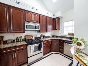 a kitchen with wooden cabinets and a stove top oven at Swampscott Retreat Four Bedrooms Come Unwind in Swampscott