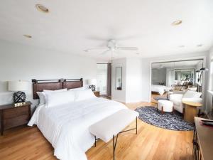 a bedroom with a large white bed and a living room at Swampscott Retreat Four Bedrooms Come Unwind in Swampscott