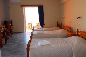 ein Hotelzimmer mit 4 Betten und einem Fenster in der Unterkunft Memi View B3 in Koroni