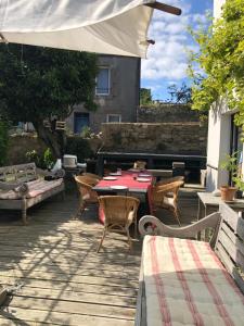 a patio with a table and chairs and an umbrella at Villa aux roses in Roscoff +9 photos