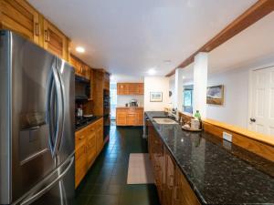 uma cozinha com um frigorífico de aço inoxidável e armários de madeira em Berkshire Vacation Rentals: Spacious & Serene Berkshires Retreat In The Woods em West Stockbridge