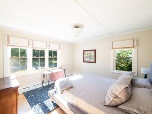 a bedroom with a large bed and two windows at Berkshire Vacation Rental: Stockbridge Home Come Experience The Berkshires in Stockbridge