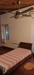 a bedroom with a bed with a ceiling fan at The Heritage Home Stay in Mysore