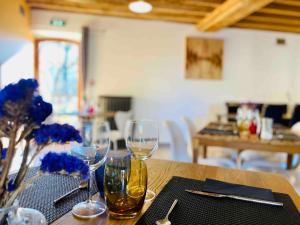 a table with two wine glasses on a table at Hameau de la Fausse Sauge in Mézilles