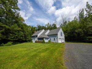 a large white house with a lot of green grass at Berkshire Vacation Rentals: Pristine Home In Becket Woods in Becket