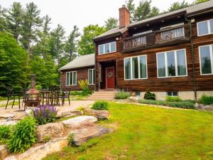 a log house with a patio and a yard at Private Berkshires Home On 5+ Acres Rustic & Chic in Otis