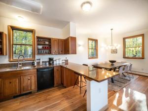 a kitchen with wooden cabinets and a dining table at Private Berkshires Home On 5+ Acres Rustic & Chic in Otis