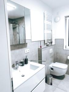 a bathroom with a white sink and a toilet at DoreyHome P2 - modernes zentrales Apartment -2-4 Personen - Parkplatz in Passau