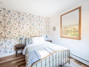 Schlafzimmer mit einem Bett mit Blumentapete in der Unterkunft Private Berkshires Home On 5+ Acres Rustic & Chic in Otis