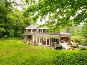 ein altes Haus mit einer Veranda und einem Hof in der Unterkunft Classic Stockbridge Cottage in Stockbridge