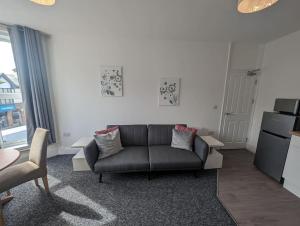 a living room with a couch and a kitchen at Seaview House - Flat 2 in Lowestoft