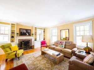 ein Wohnzimmer mit Sofas und Stühlen sowie einem Kamin in der Unterkunft Classic Stockbridge Cottage in Stockbridge