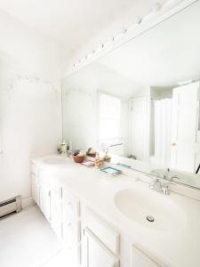 ein weißes Badezimmer mit Waschbecken und Spiegel in der Unterkunft Classic Stockbridge Cottage in Stockbridge