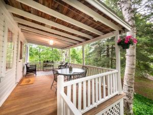 Berkshire Vacation Rentals: Private Cottage Come Enjoy Nature في Canaan: شرفة بيضاء عليها طاولة وكراسي