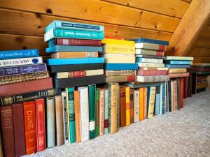 un montón de libros sentados en un estante en Berkshire Vacation Rentals: Beautiful Barn Style Home On Otis Reservoir, en East Otis