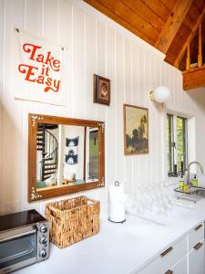 encimera con espejo y lavabo en Berkshire Vacation Rentals: Beautiful Barn Style Home On Otis Reservoir, en East Otis
