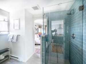 a bathroom with a glass shower with blue tiles at Tranquil Views On Planting Island Cove in Marion