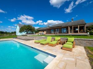 una piscina con sillas verdes y una casa en Berkshire Vacation Rentals: Private Oasis: 16 Acres Pool, en Chatham