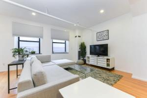 a living room with a couch and a tv at South End Hospitality: Downtown Crossing Large Lofted Condo Location in Boston