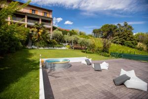 eine Terrasse mit weißen Möbeln auf einem Rasen in der Unterkunft Villa Green Paradise in Castel San Pietro Terme