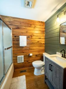 a bathroom with wooden walls and a toilet and a sink at Berkshire Vacation Rentals: Private Cabin On Over 12 Acres Of Woods in Becket