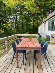 uma mesa de madeira e cadeiras num deque em Berkshire Vacation Rentals: Chic Pittsfield Home With A View em Pittsfield