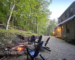 皮茨菲爾德的住宿－Berkshire Vacation Rentals: Chic Pittsfield Home With A View，一群长椅坐在 ⁇ 火旁