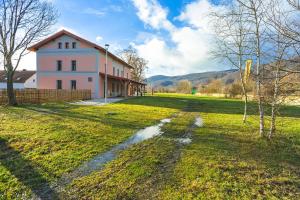 a large building with a grass field in front of it at Hotel Nádraží 