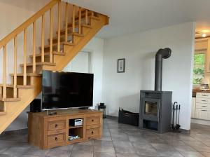 a living room with a tv and a wood stove at Deichbrise in Greetsiel